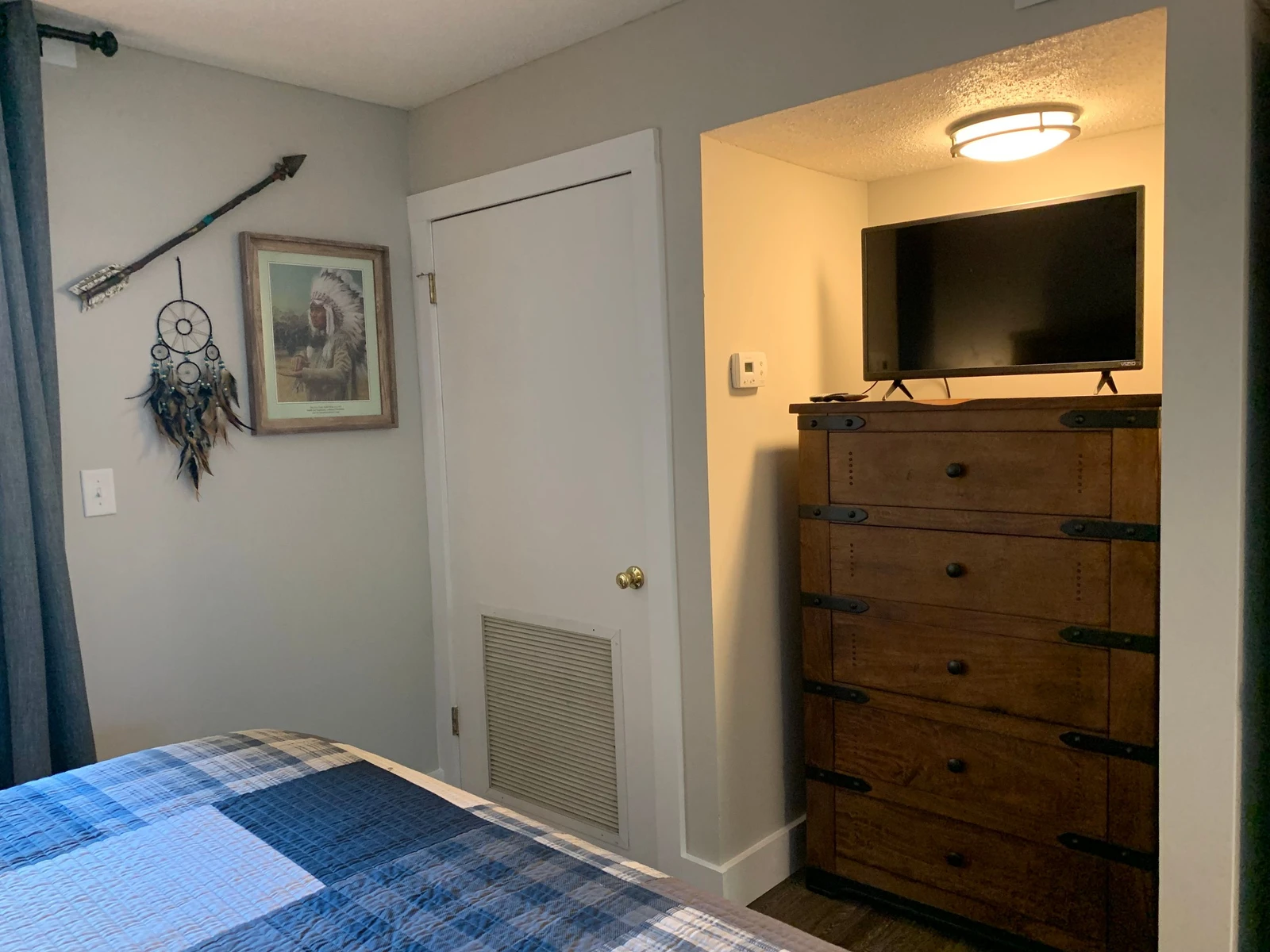Your cozy bedroom features rustic charm with handcrafted furniture and thoughtful Native American decor, plus a wall-mounted TV for your relaxation.