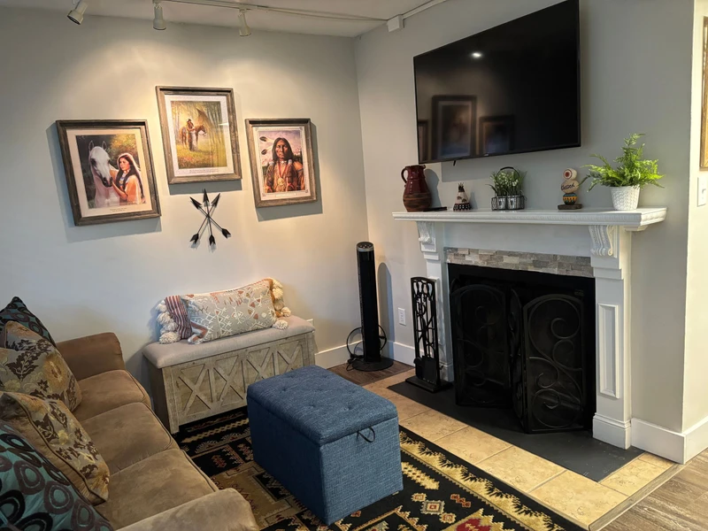 Relax in your cozy living space with a charming fireplace, thoughtful decor, and comfortable seating—perfect for unwinding after exploring local adventures.