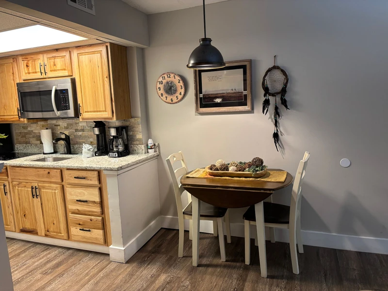 Gather around your cozy dining nook, where morning coffee feels extra special beneath a warm pendant light. Your fully equipped kitchen awaits with granite counters and all the essentials for homemade meals.