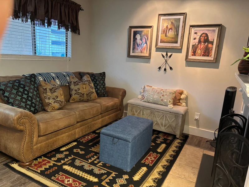 Sink into this cozy living room where southwestern charm meets comfort. Your space features a plush leather sofa, vibrant artwork, and warm lighting perfect for unwinding after adventures.