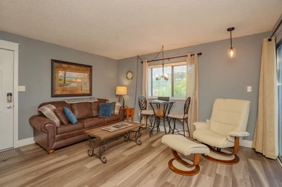 Settle into this inviting living space with its plush leather sofa, cozy recliner, and dining area bathed in natural light—perfect for your morning coffee or evening meals.