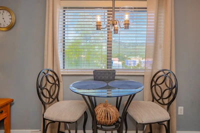 Gather around this cozy dining nook where morning coffee or evening meals feel intimate and welcoming. Natural light streams through the window, creating a peaceful spot to start your day or unwind.