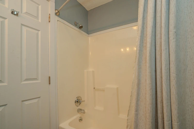 Your private bathroom features a spotless tub-shower combo with soothing coastal tones, perfect for unwinding after a day of exploring the area.