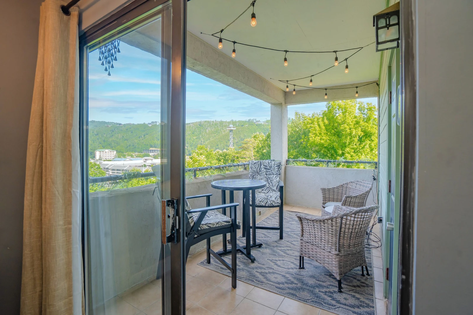 Step onto your private balcony with cozy seating, twinkling string lights, and serene views of lush greenery and rolling hills. Perfect for morning coffee or evening relaxation.