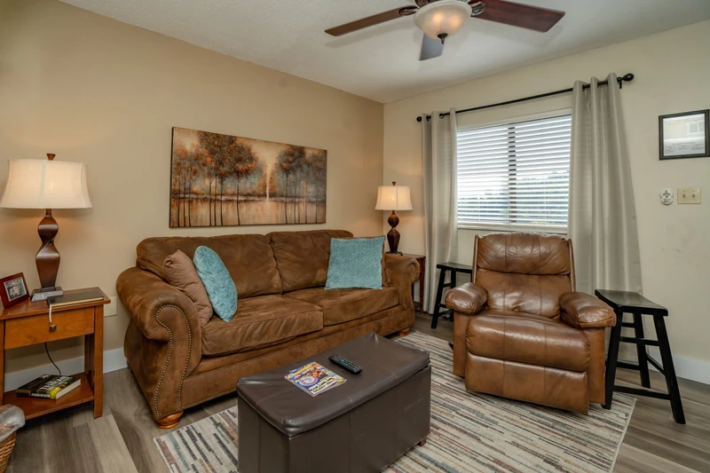 Sink into the plush leather sofa in your cozy living room, where soft lighting and inviting artwork create a relaxing space for your downtime.