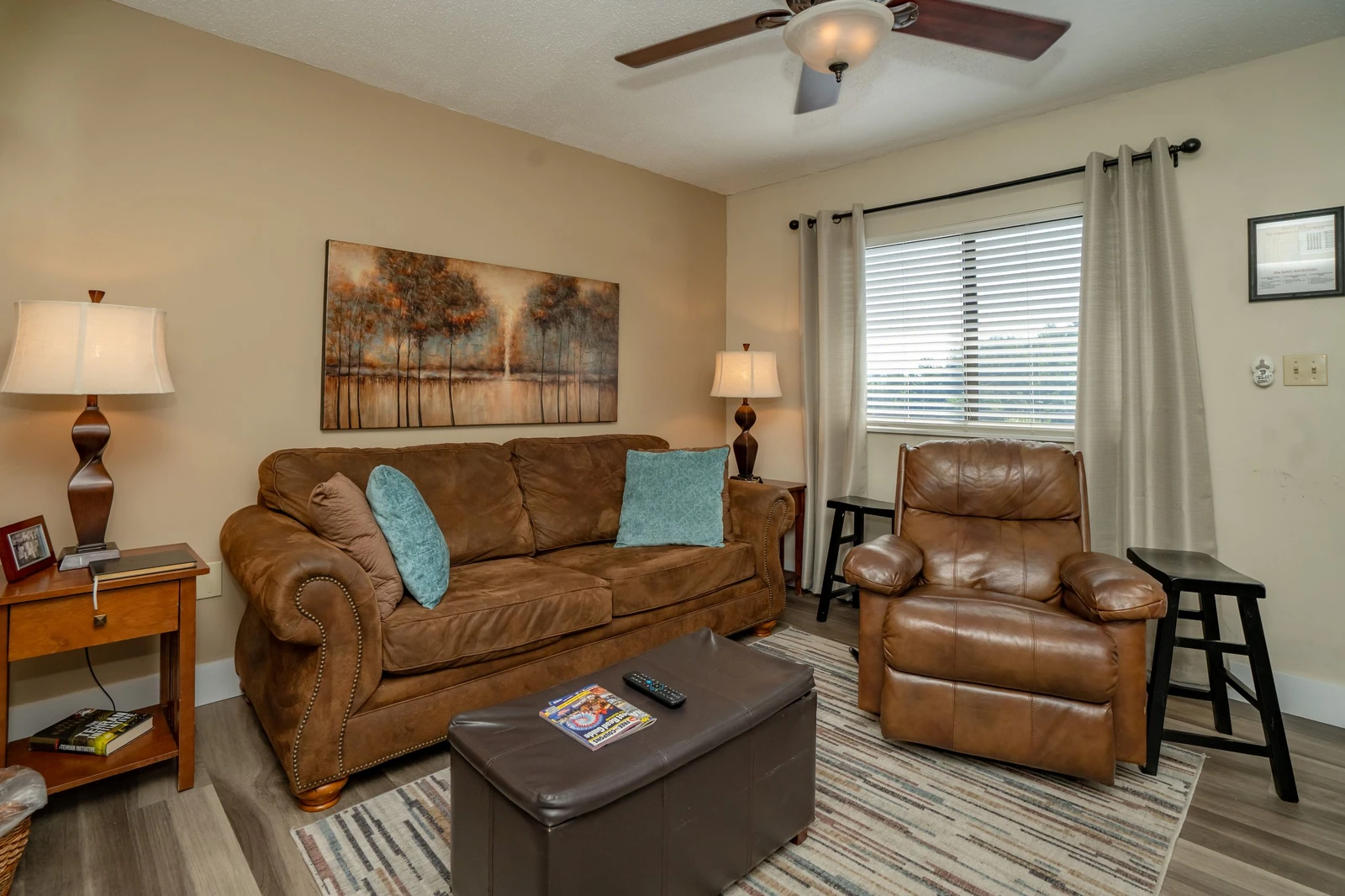 Sink into the plush leather sofa in your cozy living room, where soft lighting and inviting artwork create a relaxing space for your downtime.