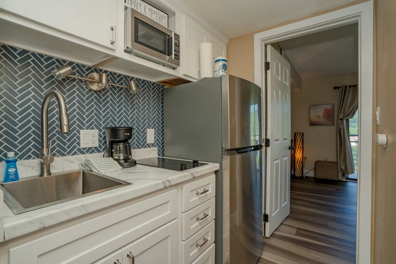 Step into your fully equipped kitchen with modern stainless-steel appliances, marble-style countertops, and a striking herringbone tile backsplash. Everything you need to prepare your favorite meals awaits.