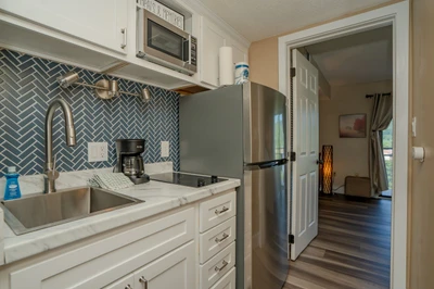 Step into your fully equipped kitchen with modern stainless-steel appliances, marble-style countertops, and a striking herringbone tile backsplash. Everything you need to prepare your favorite meals awaits.