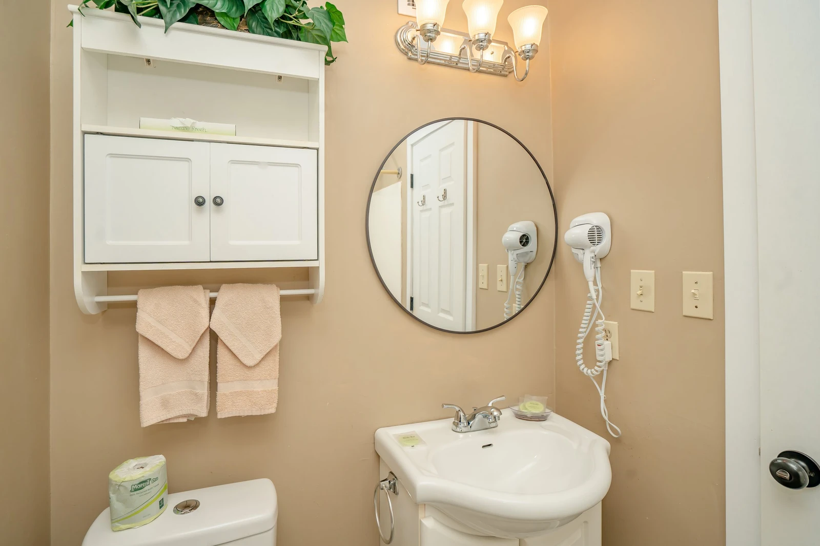 Freshen up in your private bathroom with plush towels, a lit vanity mirror, and hair dryers ready for your convenience.