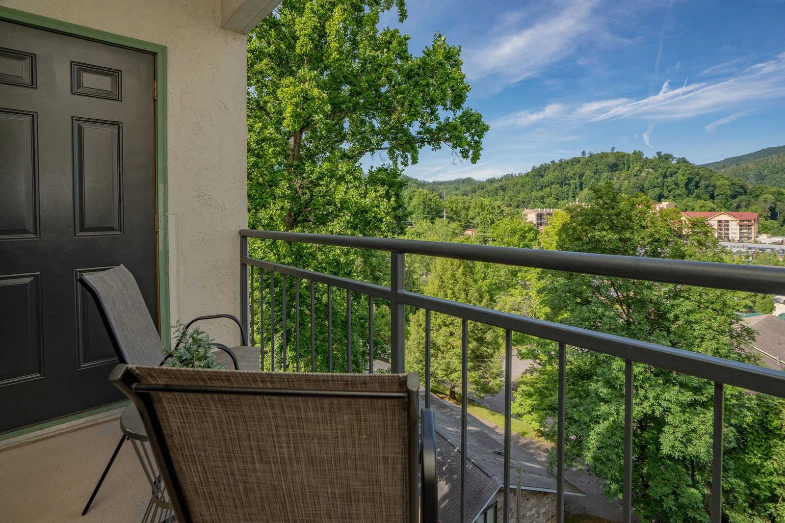 Take in panoramic views of lush green mountains and vibrant foliage from your private balcony, where comfortable seating invites you to relax and soak in the natural beauty surrounding your retreat.