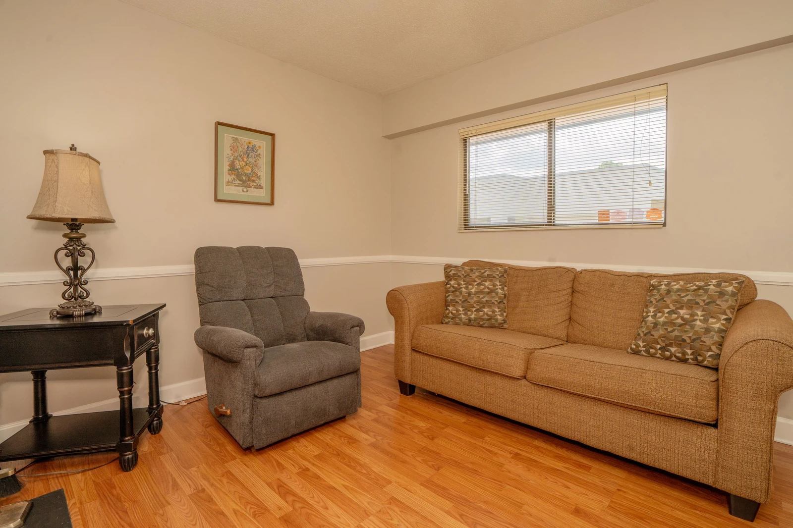 Settle into your cozy living space with warm hardwood floors and comfortable seating. Natural light filters through the window, creating an inviting spot to relax after your day's adventures.