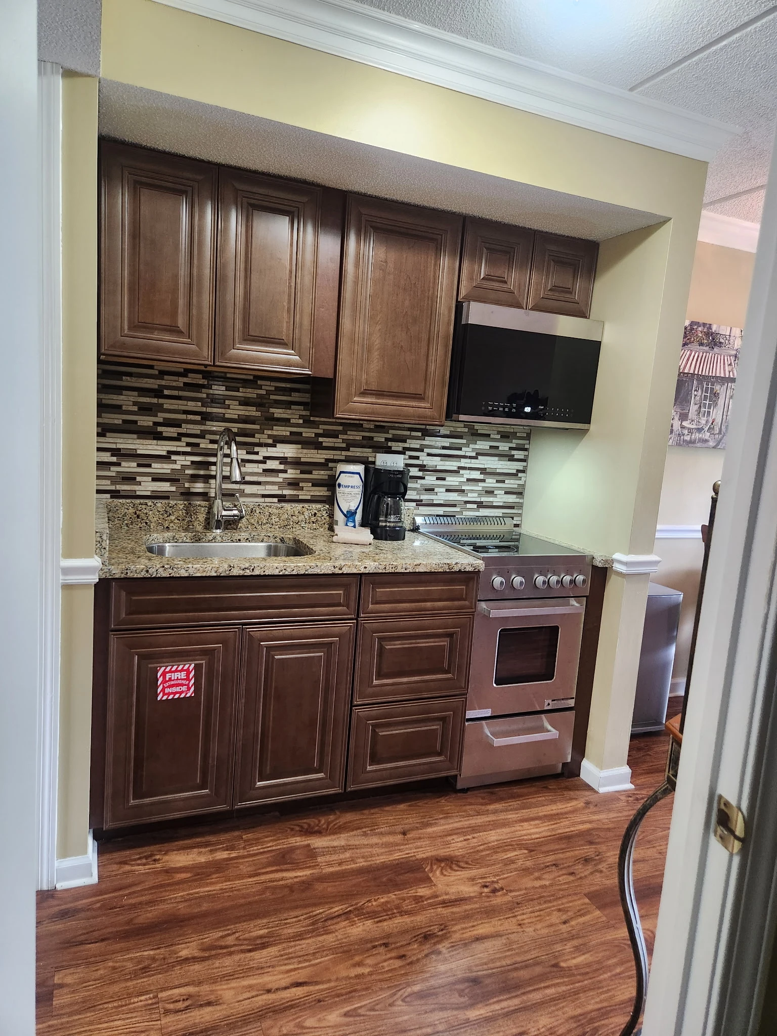 Your fully equipped kitchenette features rich wood cabinetry, granite countertops, and modern appliances—everything you need to prepare meals in comfort during your stay.