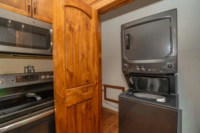Everything you need for an effortless stay: a fully equipped kitchen with stainless steel appliances and convenient in-unit washer and dryer, all wrapped in warm wood finishes that make it feel like home.
