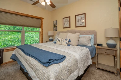 Unwind in your serene bedroom, where soft linens and a gentle ceiling fan invite restful nights. Natural light from the garden window fills the space with warmth.
