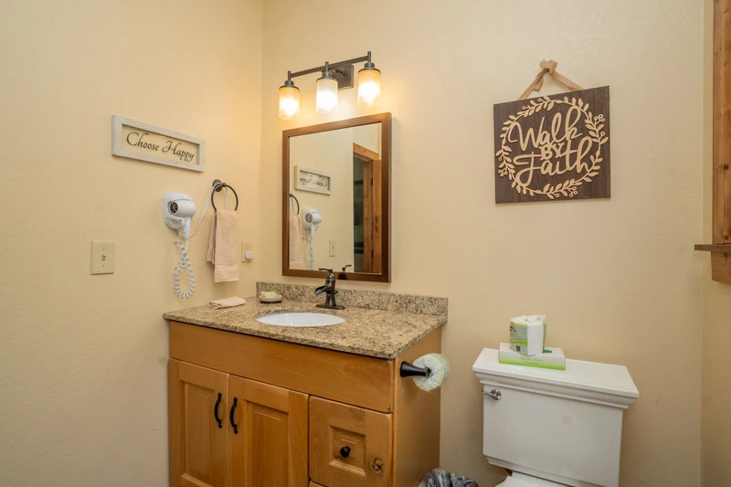 Step into a bright, thoughtfully appointed bathroom with warm wood tones and welcoming touches that make your stay feel like home.