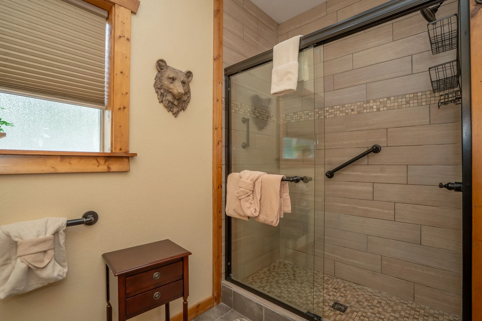 Step into your private spa-like retreat with a spacious walk-in shower, warm wood accents, and plush towels waiting for you after a day of mountain adventure.