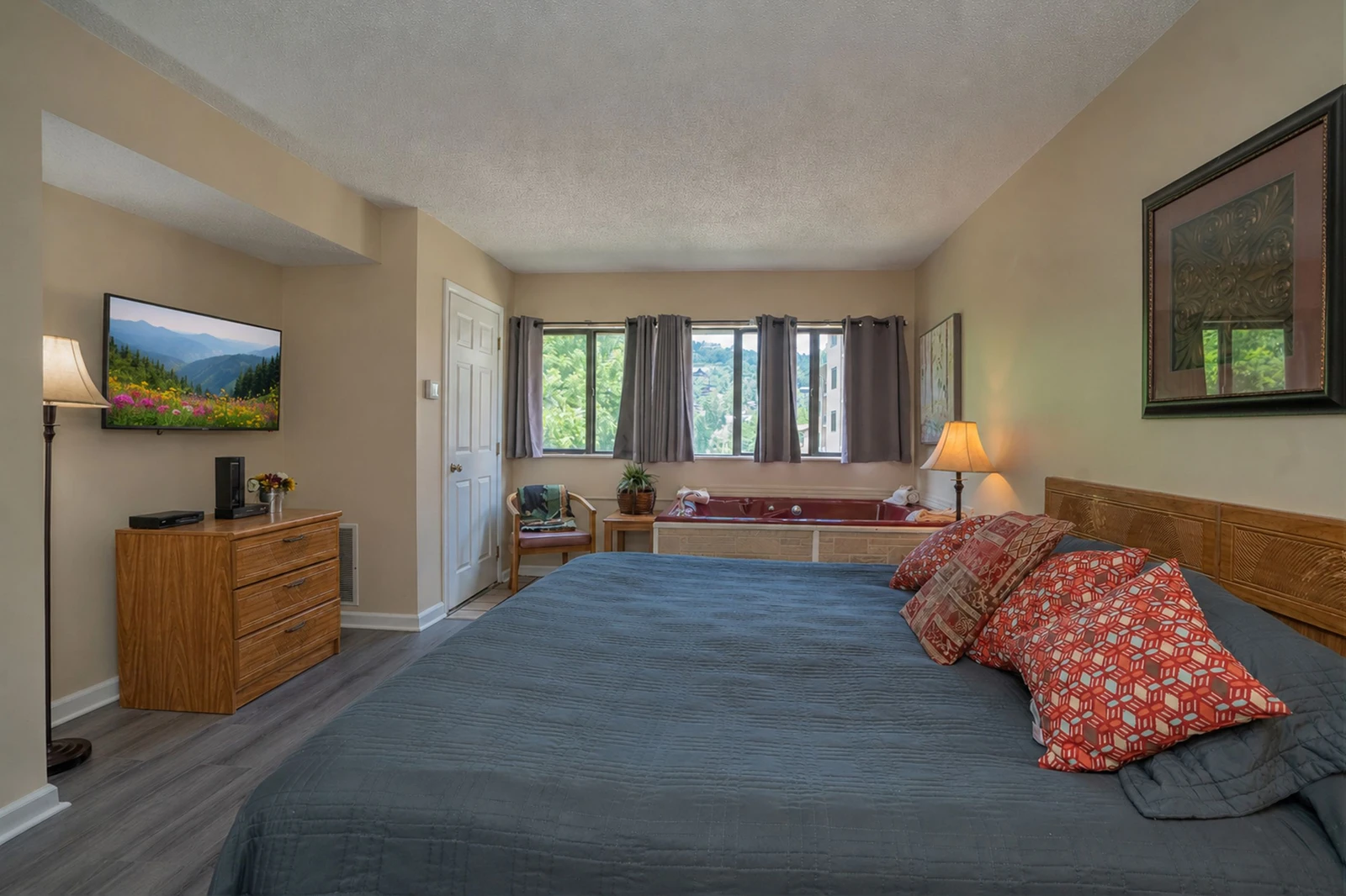 Your spacious retreat features calming tones, plush bedding, and natural light pouring through large windows. Unwind in the private hot tub after a day exploring the area, and enjoy modern comforts like a flat-screen TV and cozy seating nook.