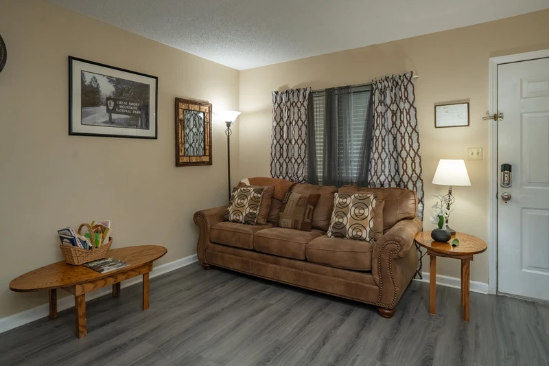 Settle into your cozy living room, where a plush sofa and warm lighting invite you to unwind after a day of exploring. The comfortable seating area offers a perfect spot to relax and plan your next adventure.