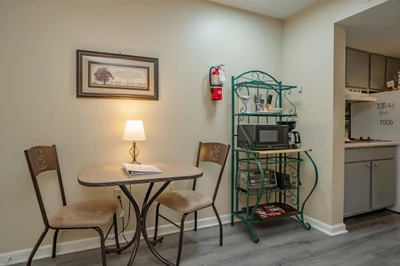 Your cozy dining nook invites you to enjoy morning coffee or a casual meal at the intimate café-style table. A teal shelving unit holds snacks and a microwave for your convenience.