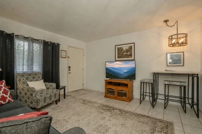 Step into your cozy retreat with tile floors, comfy seating, and warm lighting. The open layout blends the living area with a dining nook, creating a welcoming spot to unwind after exploring.