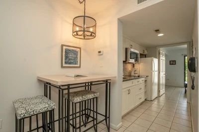 Bright, open-concept space perfect for your morning coffee and meal prep, with a cozy breakfast bar and a fully equipped kitchen just steps away.