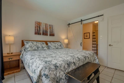 Sink into soft linens and unwind in your peaceful bedroom retreat. The charming barn door adds rustic character, while warm bedside lighting sets the mood for relaxation.