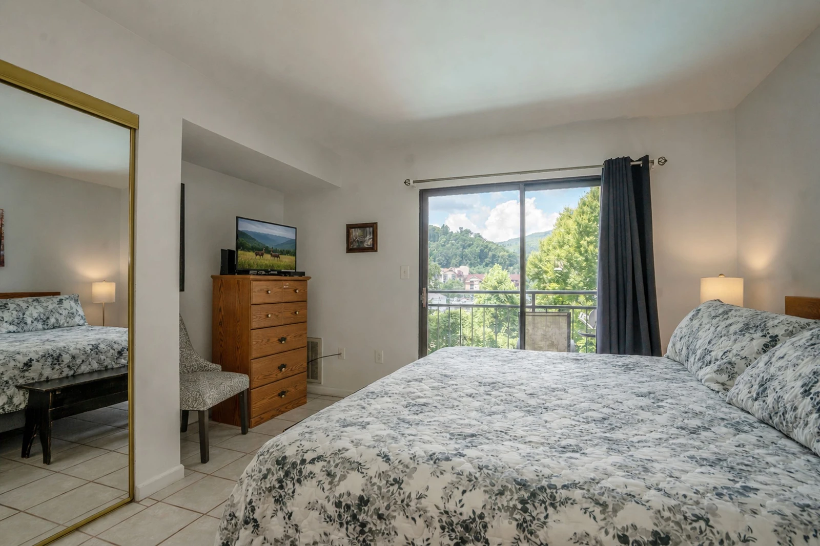 Your peaceful retreat features a plush queen bed dressed in soft linens and opens to a private balcony where mountain and lush greenery views await. Natural light floods the space, making it feel bright and airy.