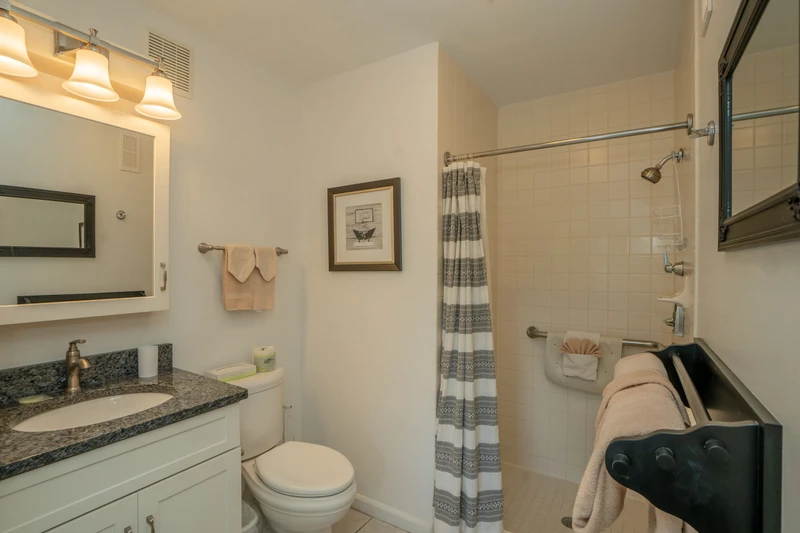 Refresh in your clean, inviting bathroom with a granite vanity, tiled shower, and thoughtfully placed towels ready for your stay.