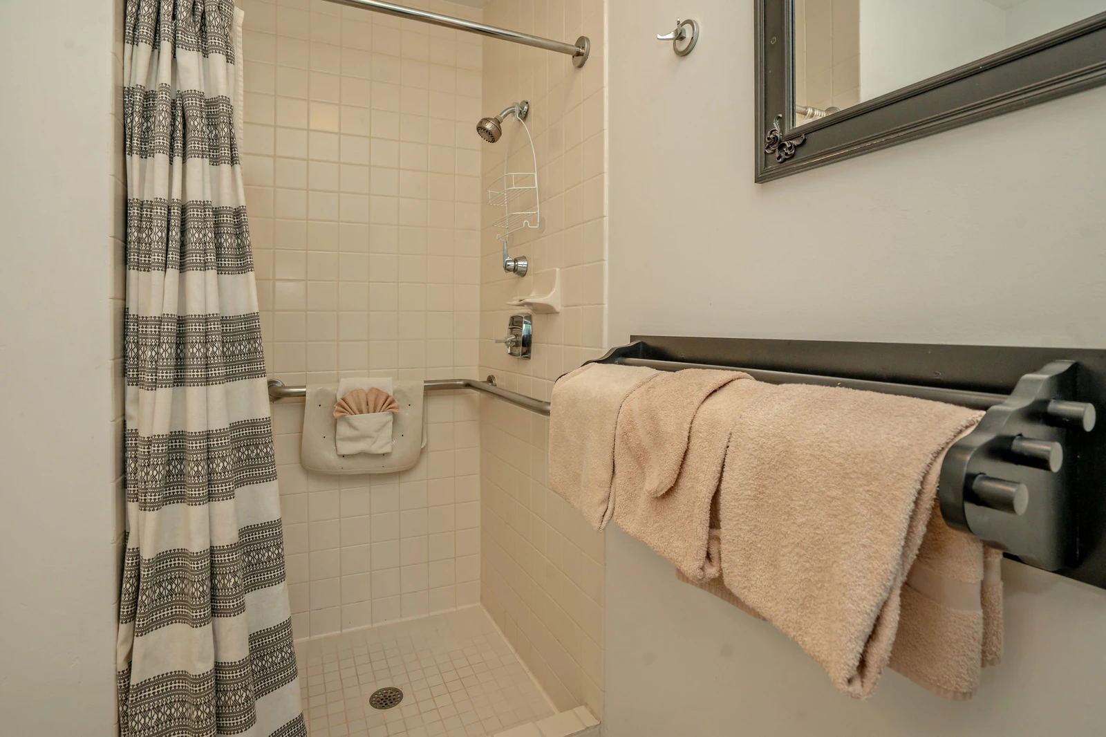 Your bathroom features a convenient walk-in shower with fresh towels ready for you. The thoughtfully designed space includes grab bars for added safety and comfort during your stay.