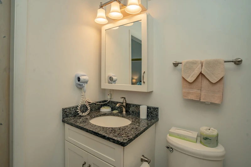 Your spotless bathroom features a granite vanity, warm lighting, fresh towels, and thoughtful touches like a hair dryer—everything you need to refresh and unwind.