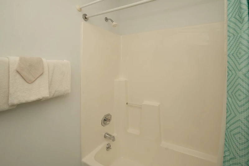 Your private bathroom features a spotless tub-shower combo with fresh towels and a modern showerhead—perfect for unwinding after a day of exploring.