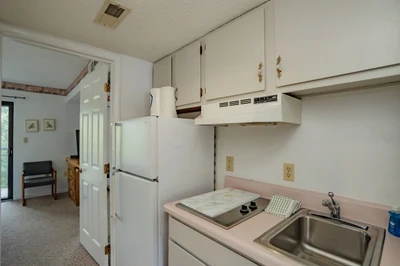 Your kitchen is fully equipped with everything you need for meal prep, featuring a stove, refrigerator, and ample counter space for easy cooking during your stay.