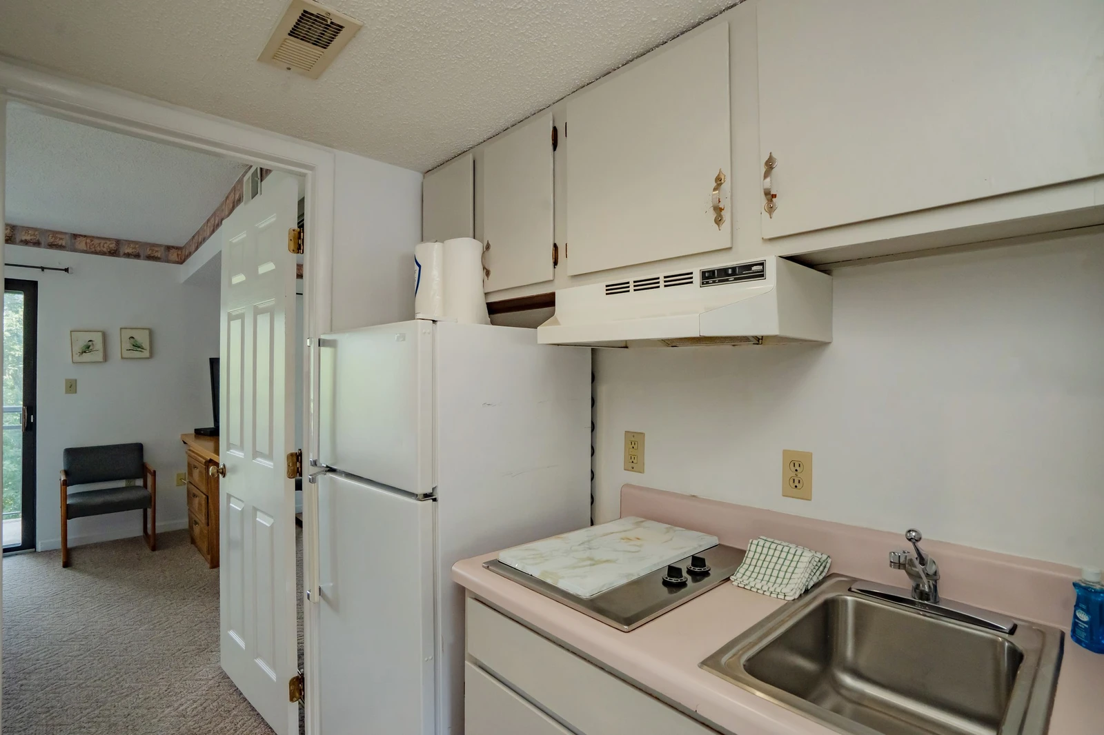 Your kitchen is fully equipped with everything you need for meal prep, featuring a stove, refrigerator, and ample counter space for easy cooking during your stay.