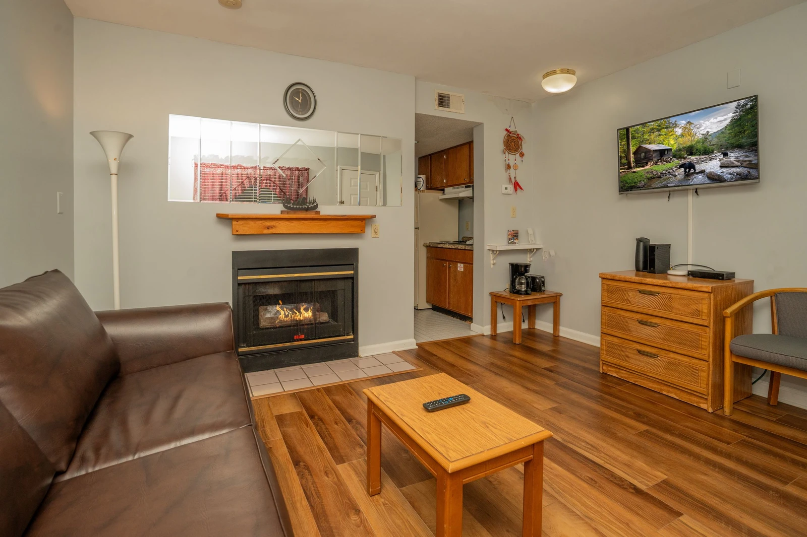 Unwind in your comfortable living space with a cozy fireplace, polished wood floors, and modern entertainment setup—your perfect retreat after a day of adventure.