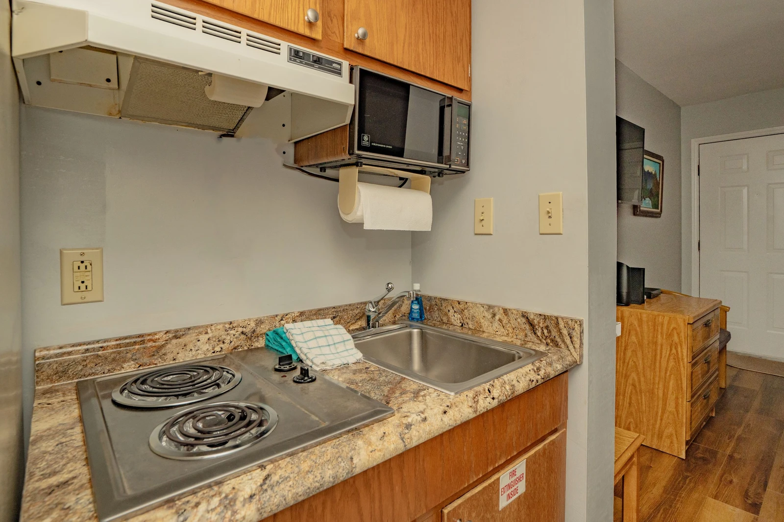 Your compact kitchenette has everything you need: a microwave, stove, and sink with granite countertops, plus handy under-cabinet storage for easy meal prep.