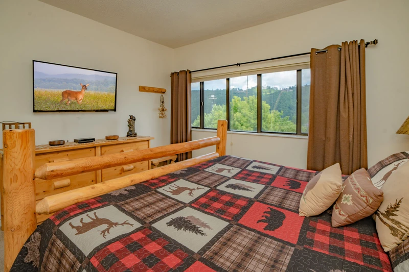 Wake up to stunning natural vistas from your cozy bedroom. The window frames peaceful greenery and rolling hills, letting you start each morning surrounded by nature's beauty.