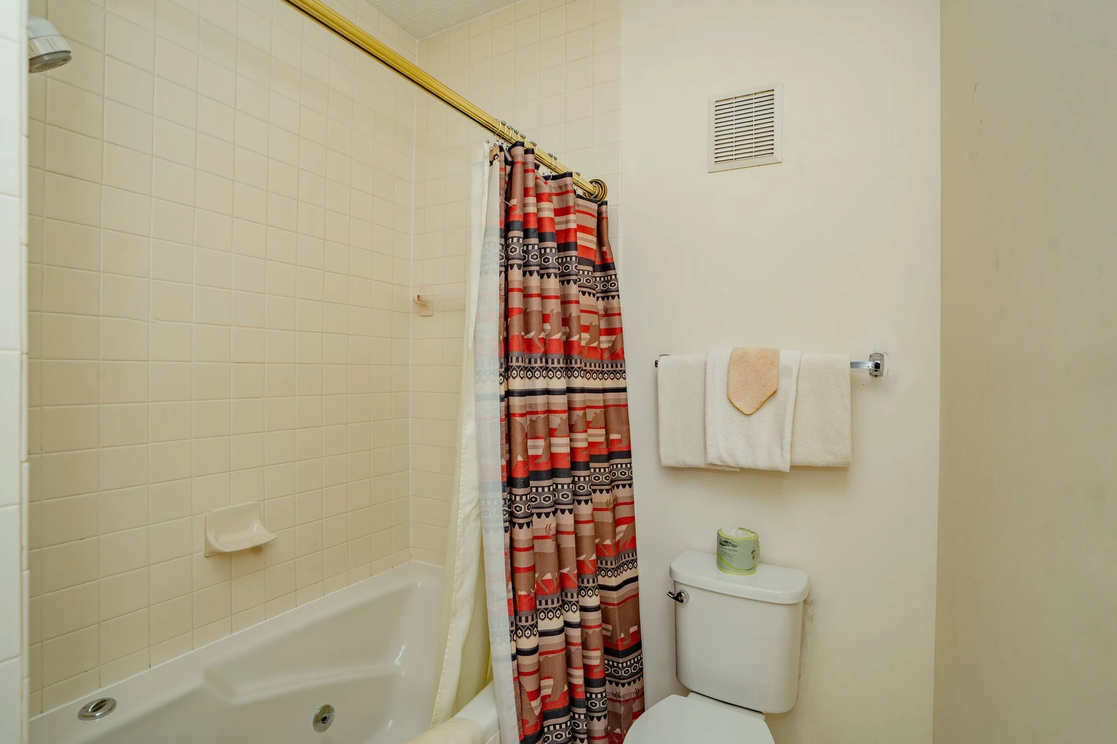 Your private bathroom features a relaxing tub-shower combo with warm Southwestern accents and fresh towels ready for your stay.