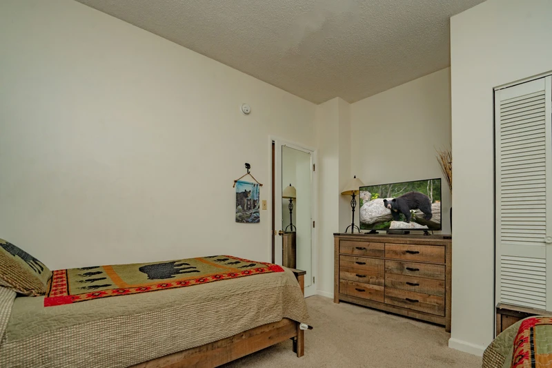 Your cozy bedroom awaits with rustic wood furnishings and a warm, inviting atmosphere. Unwind after a day of adventure in this comfortable space designed for restful nights.