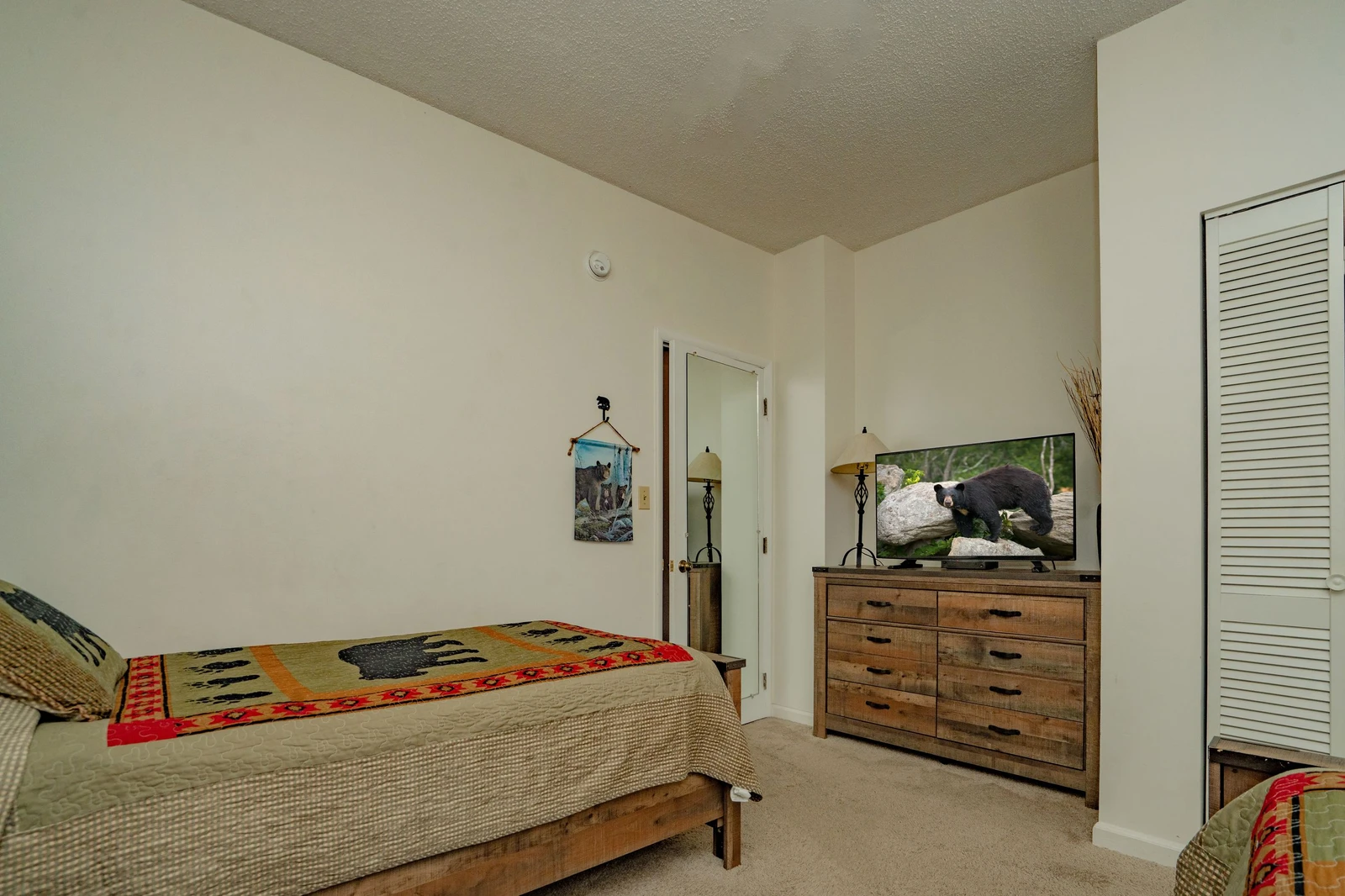 Your cozy bedroom awaits with rustic wood furnishings and a warm, inviting atmosphere. Unwind after a day of adventure in this comfortable space designed for restful nights.