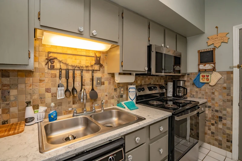 Your fully equipped kitchen awaits with warm under-cabinet lighting, charming tile backsplash, and everything you need to prepare home-cooked meals during your stay.