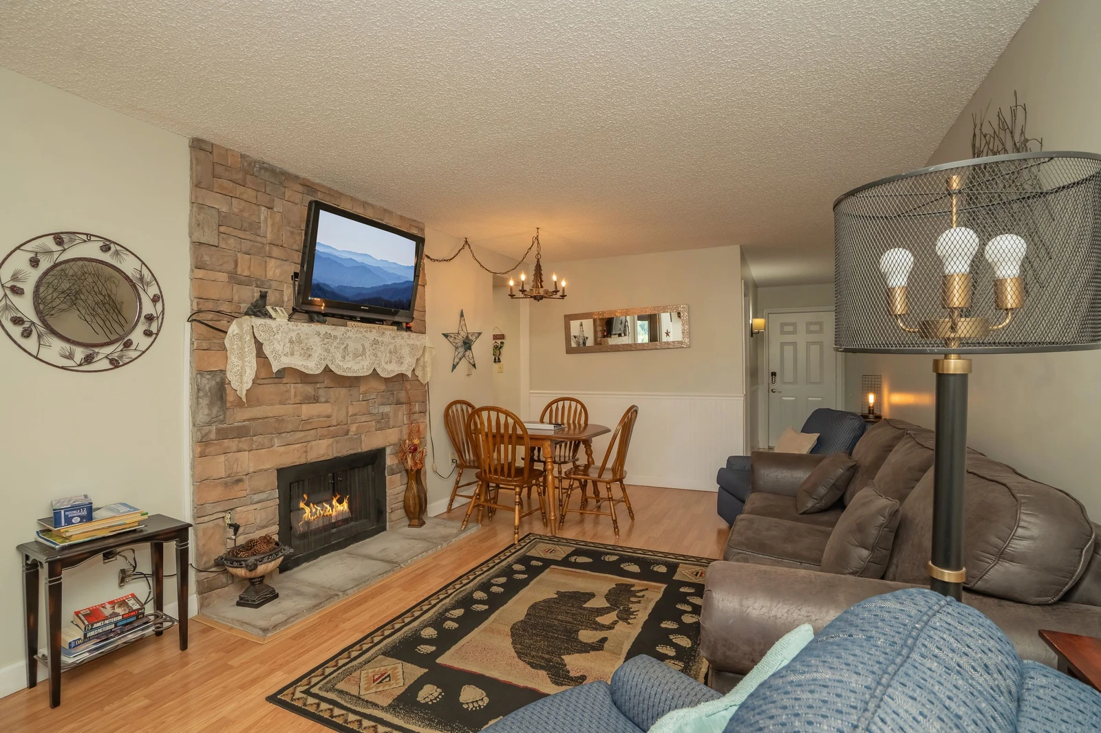 Spacious living room with a cozy fireplace and comfortable seating, seamlessly connected to the dining area—perfect for relaxing evenings and gathering with loved ones.