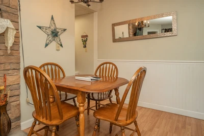 Gather around this inviting dining table for meals and conversation. The warm wood tones and cozy fireplace create a welcoming space where you can enjoy quality time together.
