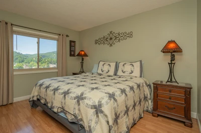 Wake up to rolling mountain vistas framed by your window, where soft morning light fills this peaceful bedroom retreat with warmth and tranquility.