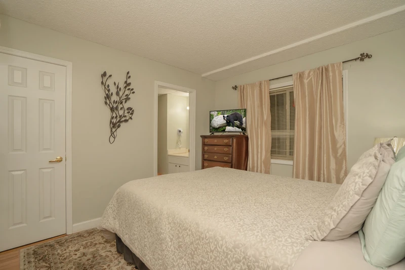 Unwind in this peaceful bedroom featuring soft linens, warm tones, and a cozy atmosphere—your perfect retreat after a full day of adventures.