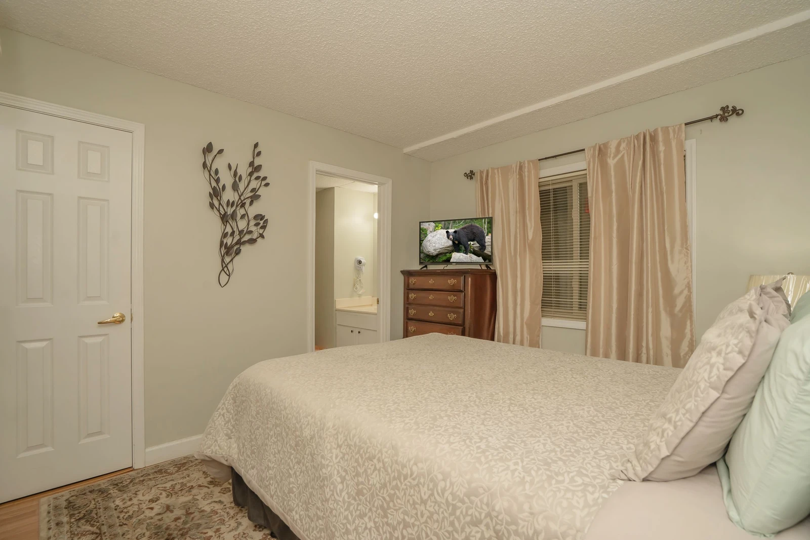 Unwind in this peaceful bedroom featuring soft linens, warm tones, and a cozy atmosphere—your perfect retreat after a full day of adventures.