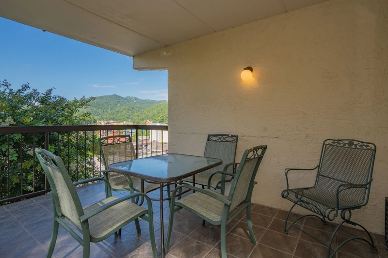 Step out to your covered balcony and enjoy dining al fresco with a stunning mountain backdrop. The table is set for leisurely meals or morning coffee as you take in the scenic views.