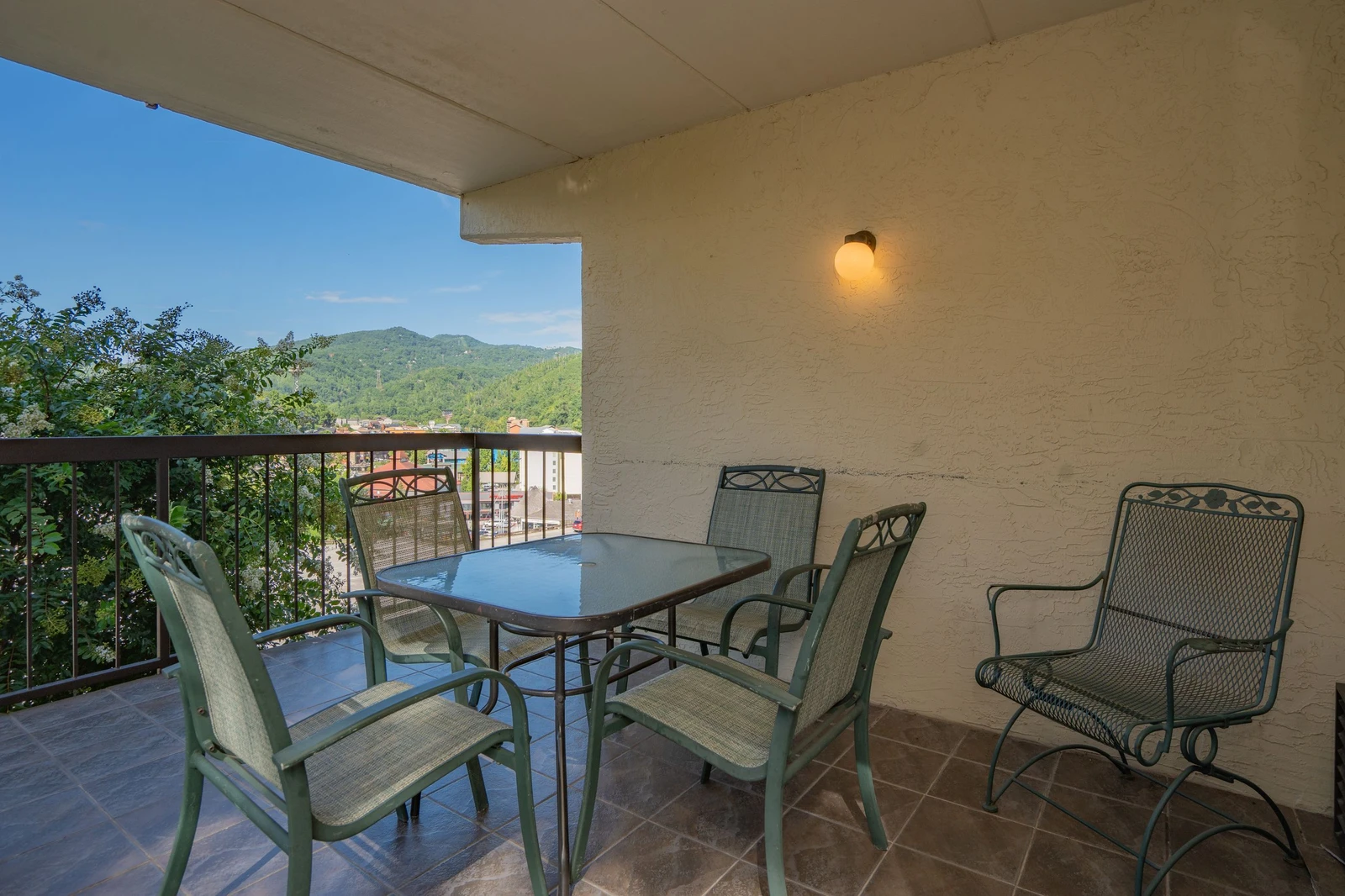 Step out to your covered balcony and enjoy dining al fresco with a stunning mountain backdrop. The table is set for leisurely meals or morning coffee as you take in the scenic views.