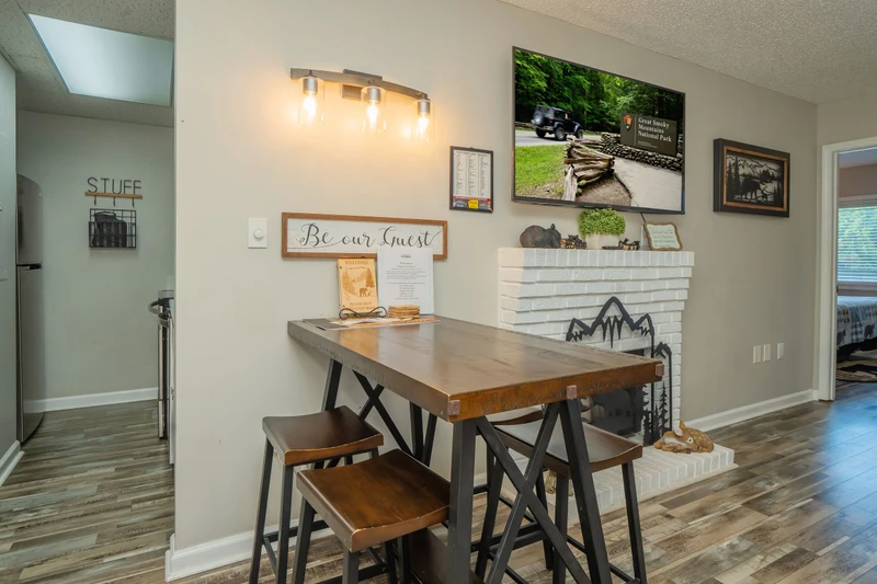 Gather around your welcoming dining space, thoughtfully styled with rustic touches and mountain-inspired decor. A skylight overhead bathes the room in natural light, creating the perfect spot for morning coffee or evening meals together.
