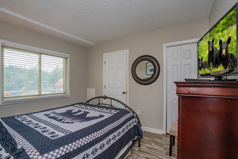 Settle into your cozy bedroom retreat with natural light streaming through the windows and a large TV for your evening entertainment.