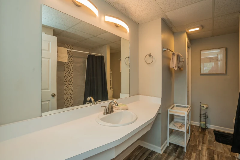 Step into your private bathroom with a spacious vanity, warm lighting, and modern finishes. Fresh towels await, and the stylish walk-in shower promises a refreshing start or relaxing end to your day.
